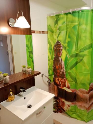 La salle de bains est pourvue d'un rideau de douche et d'une statue. dans l'établissement C210 Appartement Disneyland Paris Studio, à Montévrain