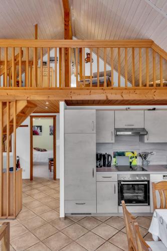 a kitchen with a wooden staircase and a loft at Chalet Friedrichsen I by Interhome in Langenhorn
