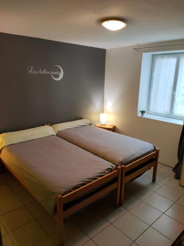 a bedroom with a bed in a room with a window at La ferme du Grand Faubourg in Pont-de-Vaux