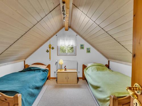 two beds in a small room with a window at Chalet Friedrichsen I by Interhome in Langenhorn