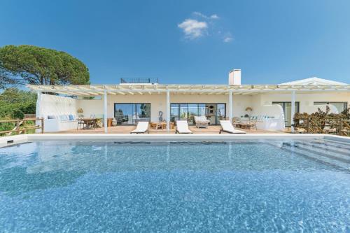 a swimming pool in front of a house at Monte da Torre in Melides