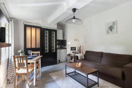 un salon avec un canapé et une table dans l'établissement Le Mirabeau - Hypercenter studio - Wifi - Train station, à Aix-en-Provence