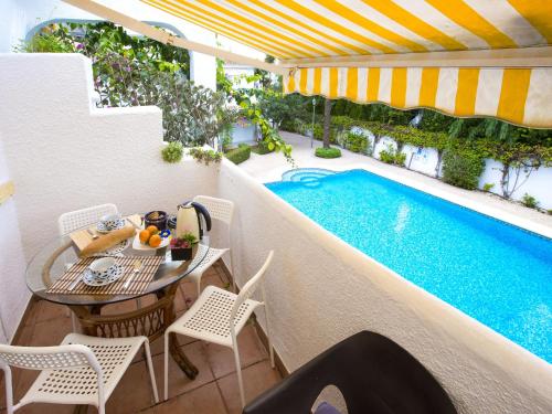 デニアにあるApartment Oasis Beach-2 by Interhomeのスイミングプールのそばにパティオ(テーブル、椅子付)
