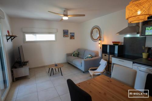 un salon avec un canapé et une table dans l'établissement Villa T3 à 400m de la plage avec piscine, à Vias