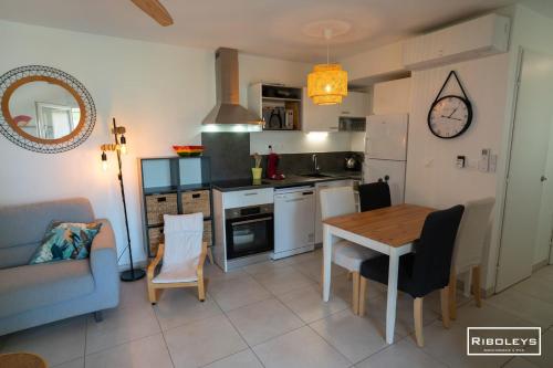 une cuisine et une salle à manger avec une table et des chaises dans l'établissement Villa T3 à 400m de la plage avec piscine, à Vias