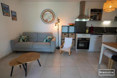 un salon avec un canapé et une table dans l'établissement Villa T3 à 400m de la plage avec piscine, à Vias