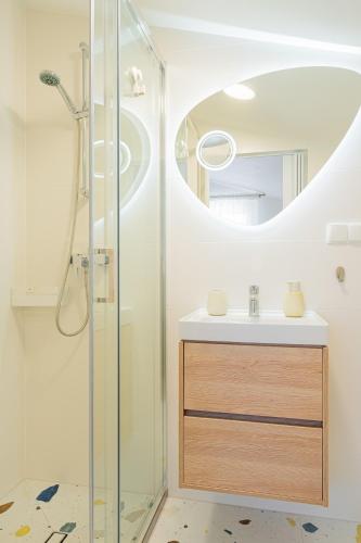 a bathroom with a sink and a shower with a mirror at BOSMAN Karwia - Pokoje 100m od Plaży in Karwia