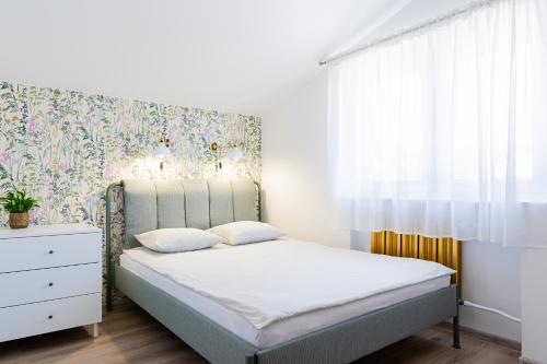 a bedroom with a bed with a floral wallpaper at BOSMAN Karwia - Pokoje 100m od Plaży in Karwia