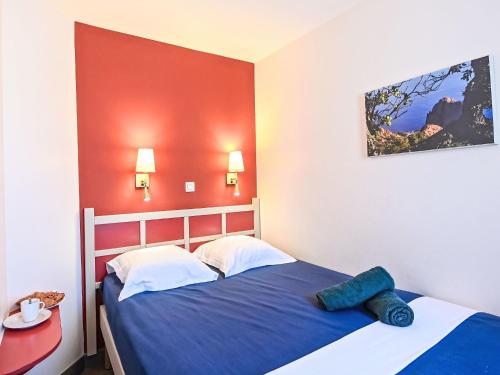 une chambre avec deux lits et un mur rouge dans l'établissement Apartment Le Belvédère - R4 317 by Interhome, à Agay
