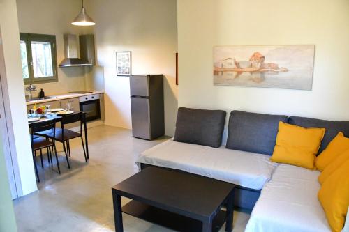 een woonkamer met een bank en een keuken bij Olive tree house in Aegina Town