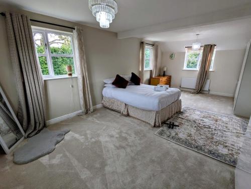 Un dormitorio con una cama y dos ventanas. en 4 Bed 4 Bathroom Home, en Muxton