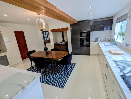 cocina con mesa de madera y electrodomésticos negros en 4 Bed 4 Bathroom Home, en Muxton