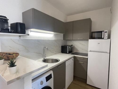 une petite cuisine avec un évier et un réfrigérateur dans l'établissement Apartment Villa Medicis-2 by Interhome, à Cavalaire-sur-Mer