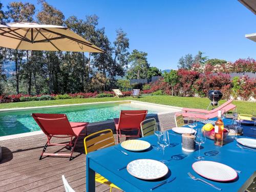 - une table bleue avec des chaises et un parasol à côté de la piscine dans l'établissement Villa Villa La Roquette sur Siagne by Interhome, à La Roquette-sur-Siagne