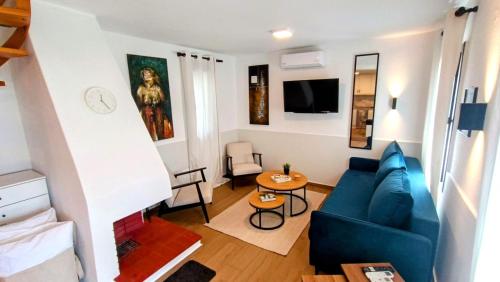 a living room with a blue couch and a table at Trikorfo Seacret in Yerakiní