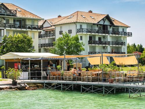 a restaurant on the water in front of a building at Studio Karen by Interhome in Balatonőszöd