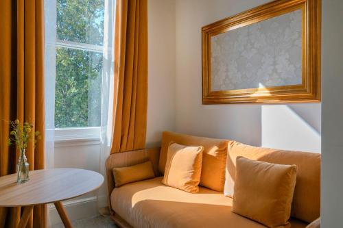 a couch in a room with a table and a window at Meliá London Kensington Member of Meliá Collection in London
