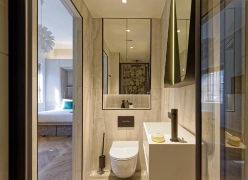 Un baño con inodoro, lavabo y cama. en South Kensington Studios by D'Montrio, en Londres