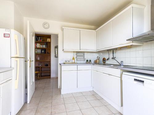 une cuisine avec des armoires blanches et des appareils électroménagers blancs dans l'établissement Apartment Baie Azur by Interhome, à Nice
