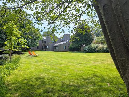 a yard with two chairs in the grass at Unique & Rural Child Friendly Annexe with Large Gardens, Games & Tennis Court - Chichester Holiday Properties in Chichester