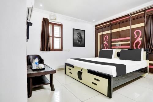 a bedroom with a bed and a desk with a computer at Super Hotel O J3 LUXURY ROOMS in Guntūr