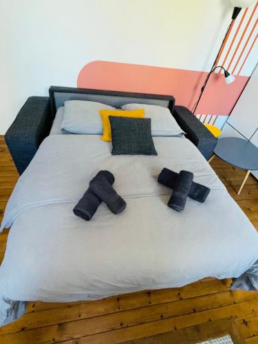 un lit avec trois oreillers noirs dessus dans l'établissement #YellowCenter #20m Jardin Public, à Cognac