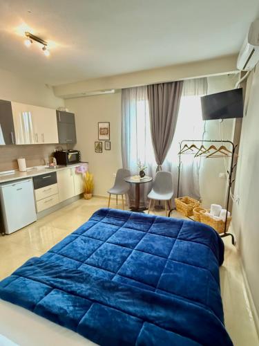 a bedroom with a blue bed and a kitchen at Sunny apartment in Serres