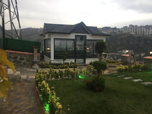 a small house with a garden in the yard at Şahin Konağı in Degirmen