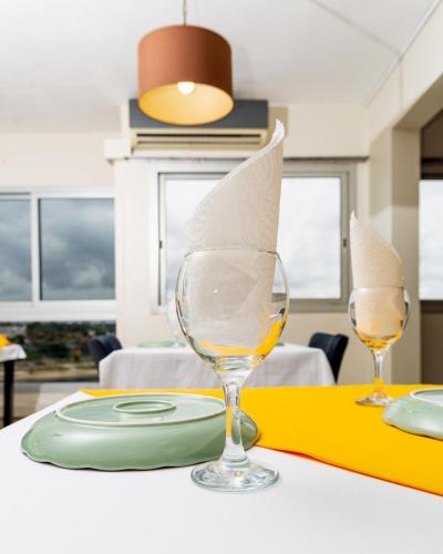 a table with two wine glasses with papers in it at Résidences Les Hauts de l'Indenié in Abidjan