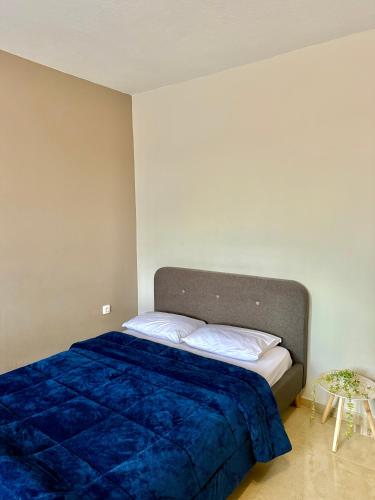 a bedroom with a bed with a blue blanket at Sunny apartment in Serres