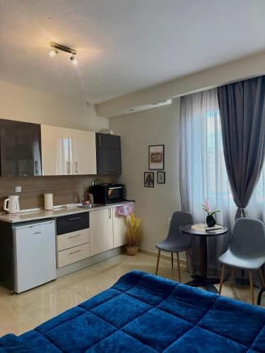 a living room with a blue bed and a kitchen at Sunny apartment in Serres