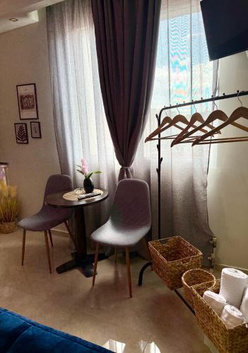 a living room with a table and chairs and a window at Sunny apartment in Serres