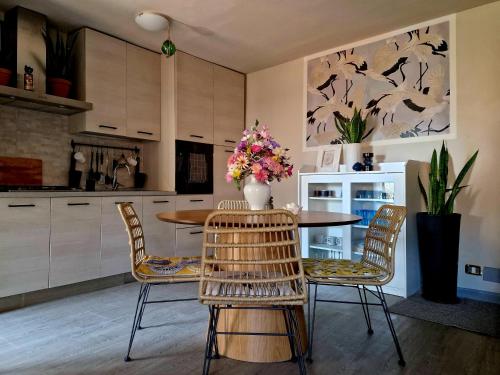 a kitchen with a table and chairs with flowers on it at Acquadolce in Salò
