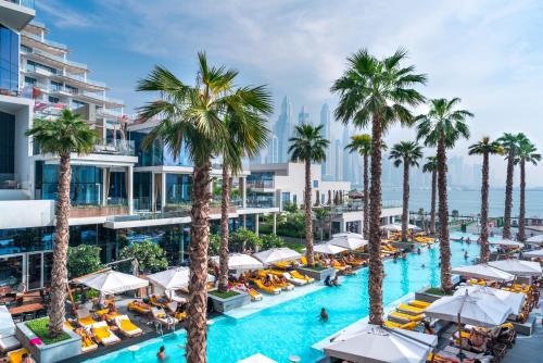 an aerial view of a resort pool with palm trees at FIVE Palm Jumeirah Residences - Mint Stay in Dubai
