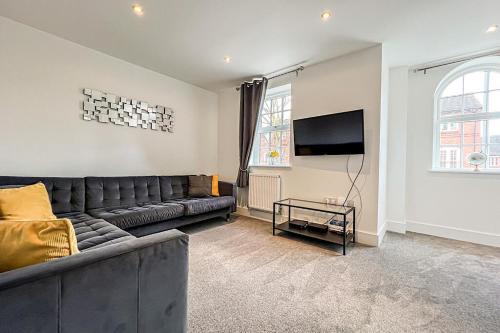 a living room with a couch and a flat screen tv at Central Warwick townhouse within easy reach of Stratford upon Avon and Cotswolds in Warwick