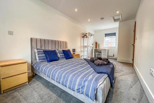een slaapkamer met een groot bed met blauwe kussens bij Central Warwick townhouse within easy reach of Stratford upon Avon and Cotswolds in Warwick