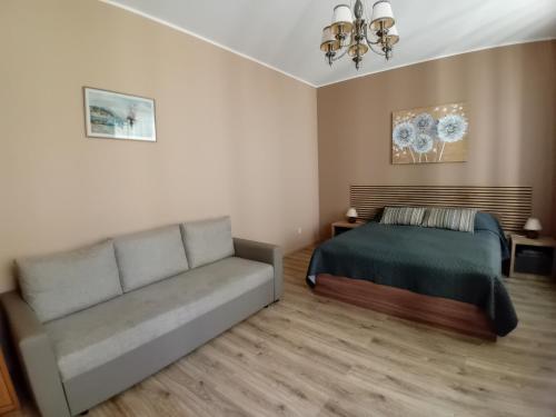 a bedroom with a bed and a couch at Jūras Brīze in Ventspils