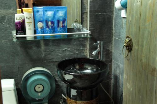 a bathroom with a black sink and a toilet at Xishan Wutong Qinyuan (Free Pick up Service) in Huangshan