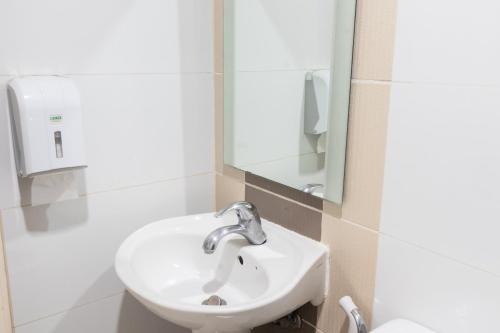 a bathroom with a sink and a mirror at Hotel Sogo Makati Avenue in Manila