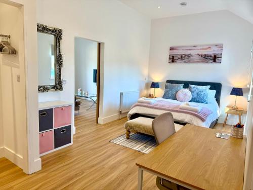 a bedroom with a bed and a table in a room at Bespoke 1 Bedroom Barn by Stansted Airport & Holiday Parking in London Stansted Airport