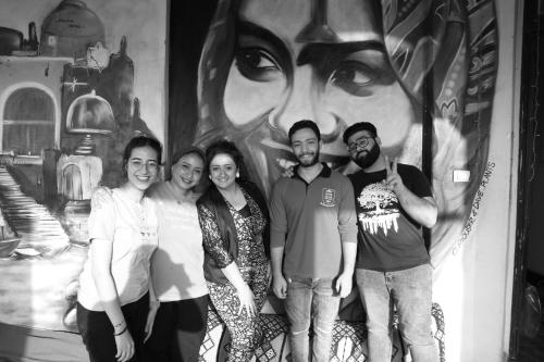 a group of people standing in front of a mural at Cecilia Hostel in Cairo