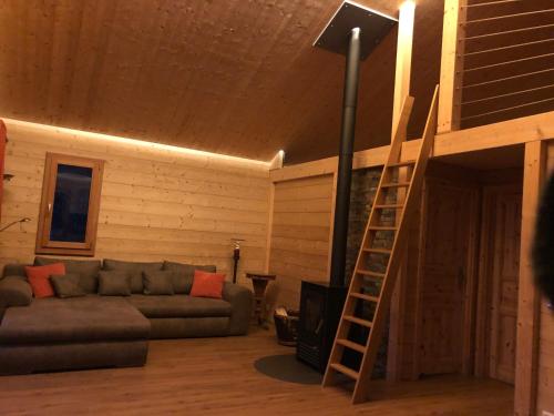 ein Wohnzimmer mit einem Sofa und einer Leiter in der Unterkunft "La Graziosa" Superior Chalet Rifugio Nel Bosco in Astano