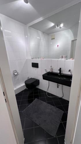 a bathroom with a black toilet and a sink at Apartmenthaus Somborn in Bochum