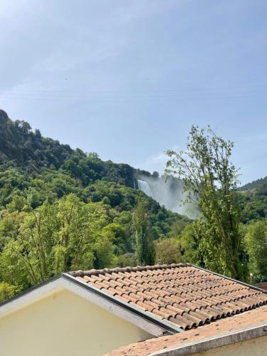 a roof of a house with a mountain in the background at Il Casolare della Cascata in Terni