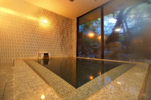 a room with a large glass window and ailed wall at Hotel Kinu in Nikko