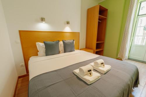 a bedroom with a large bed with towels on it at Rossio Suites By Hosty in Lisbon