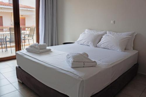 a large white bed with towels on top of it at Ble Studios in Nikiti