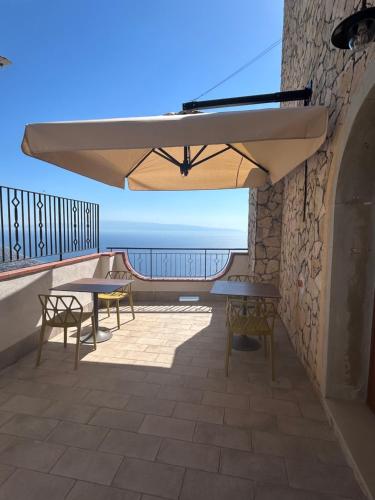 a patio with tables and a large umbrella at Domus Mea in Forza dʼAgro