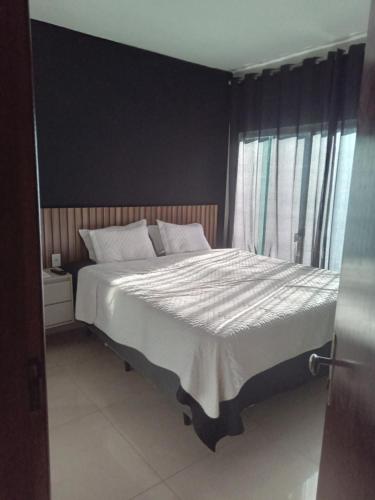 a bedroom with a large bed and a window at Casa de alto padrão in Macacos