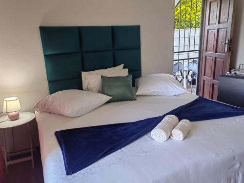 a large bed with two pillows on top of it at MayBach Hills Palace Guesthouse in Saldanha